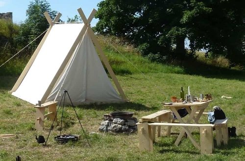 Weißes Zelt an Grillstelle auf einer Wiese Weißes Zelt an Grillstelle auf einer Wiese
