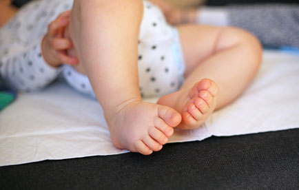 Baby auf einer wasserdichten, hygienischen Unterlage Baby auf einer wasserdichten, hygienischen Unterlage