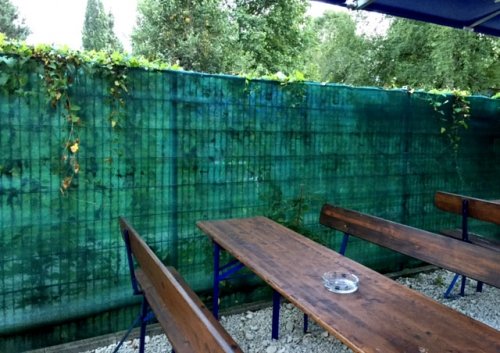 Wind- und Sichtschutz an einem Zaun im Biergarten Wind- und Sichtschutz an einem Zaun im Biergarten