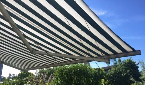 Gestreifte Markise bei sonnigem Wetter Gestreifte Markise bei sonnigem Wetter