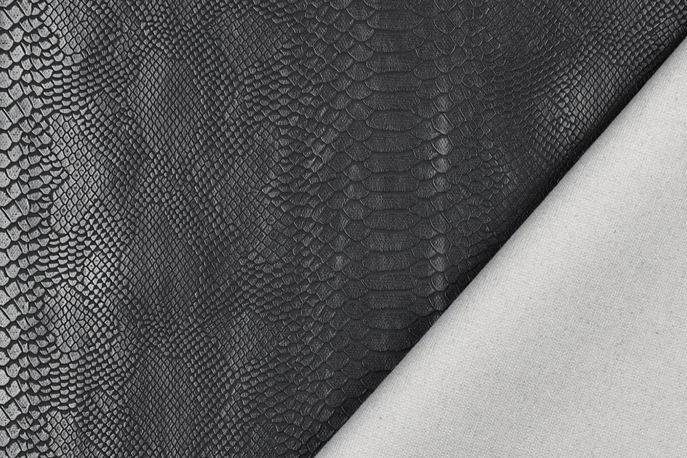 Edles Kunstleder mit realistischer Python-Prägung in Schwarz. Perfekt für Taschen, Polster, Accessoires und moderne Interior-Projekte. Kl1198 Phyton Noir Detail Kunstleder Kunstleder - Python Noir